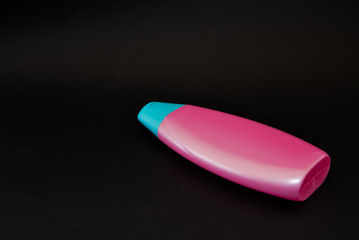 A bottle of household chemicals cosmetics on a black background neck of a bottle close up macro pattern