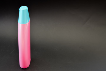 A bottle of household chemicals cosmetics on a black background neck of a bottle close up macro...