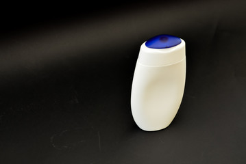 A bottle of household chemicals cosmetics on a black background neck of a bottle close up macro...