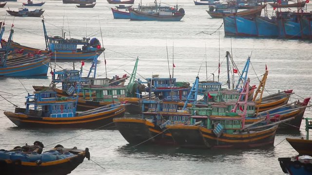 Vietnamese fishing boats on a tropical Con Dao Island. View from the pier in the direction of a beach with white sand