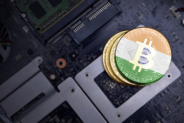 golden bitcoins with flag of india on a computer electronic circuit board. bitcoin mining concept.