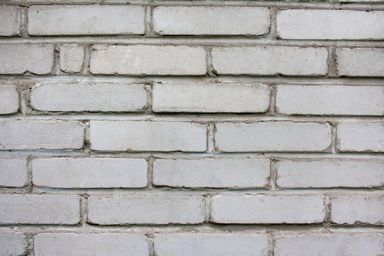 Fototapeta Stary, zniszczony mur z szarych cegieł - tło w stylu wabi-sabi