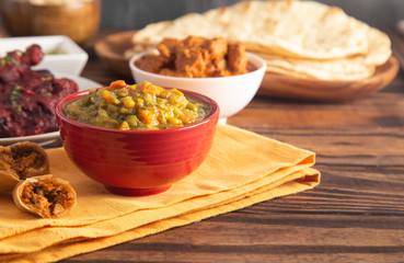Table Set with Vegetable Curry and Side Dishes on a Wooden Table