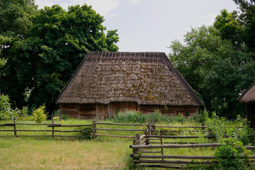 Old Ukrainian house. Ukrainian hut of the nineteenth century. Summer landscape, flowers in front of...