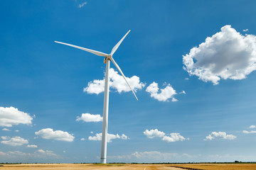 Electricity wind generator on bright cloudy sky background - wind energy and technology concept
