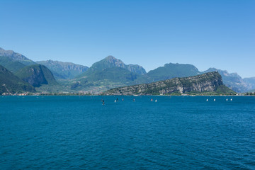 Beautiful view of Riva Del Garda and Nago-Torbole coastline and beaches with lots of windsurfers and boats, Italy