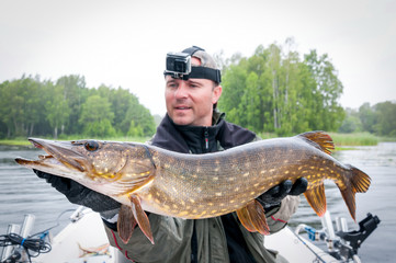 Huge pike fishing trophy in rainy day