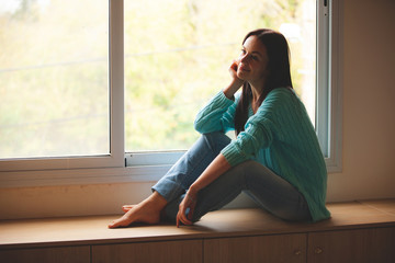 woman sitting on the window sill