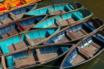 Top view of colorful, wooden flat-bottomed boats, moored on the water.