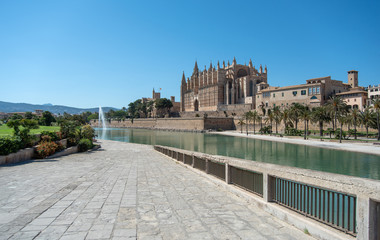 Obraz premium Majorca 2019: Panoramic view of Cathedral La Seu of Palma de Mallorca on a sunny summer day. Composition with pedestrian way leading to church in the foreground