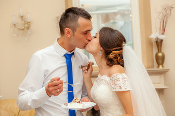 Bride and groom eat wedding cake