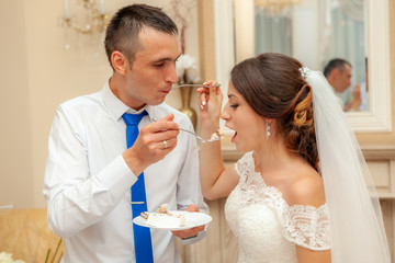 Bride and groom eat wedding cake