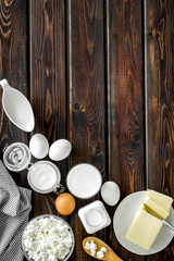Fresh dairy products for breakfast with milk, cottage, eggs, butter, yougurt on wooden background top view mock up