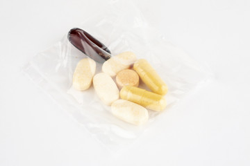 Pills dosage in plastic bag on white background