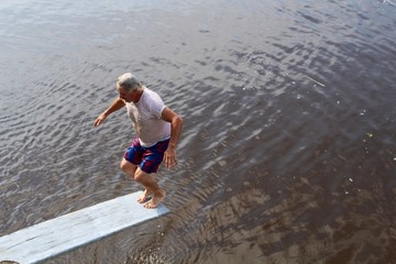 Active Senior Man on Diving Board on River