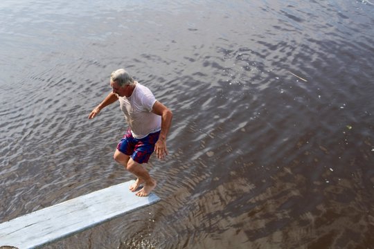 Active Senior Man On Diving Board On River