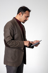 Serious young man doing finances with his calculator on a white isolated background