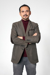 Smiling young man with a brown vintage jacket stands on a white isolated background