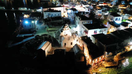 Aerial drone night shot of iconic and picturesque illuminated Little Venice in main town of Mykonos island nect to famous chapel of Paraportiani, Cyclades, Greece