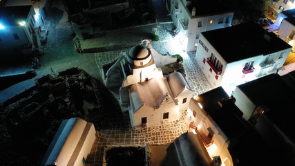 Aerial drone night shot of iconic and picturesque illuminated Little Venice in main town of Mykonos island nect to famous chapel of Paraportiani, Cyclades, Greece