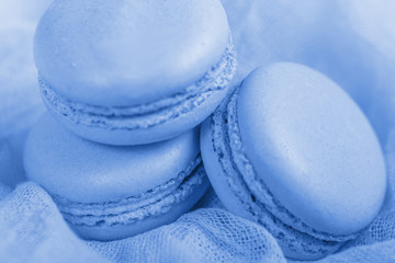 Delicious french dessert. Three gentle soft pastel blue cakes  macaron or macaroon on airy fabric,