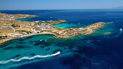 Aerial drone bird's eye view from famous beach of Paraga and Agia Anna featuring iconic Skorpios club and Santa Anna with largest pool in Europe, Mykonos island, Cyclades, Greece