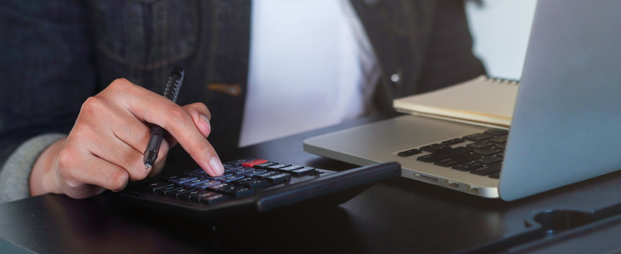 close up on mother hand finger press on calculator for manage expenses concept	