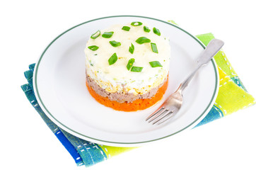 Portion layered salad with fish, carrots and eggs. 