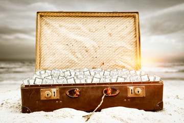 Summer suitcase of ice cubes on beach and free space for your decoration. 