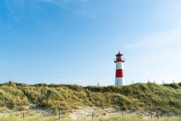 Fototapeta na wymiar Lighthouse red white on dune. Sylt island – North Germany. 