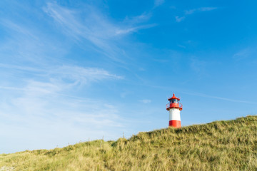 Fototapeta na wymiar Lighthouse red white on dune. Sylt island – North Germany. 