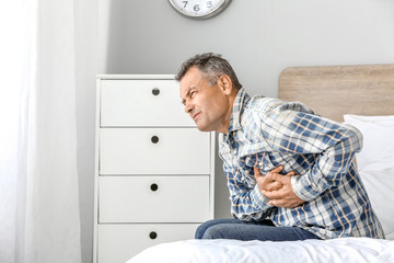 Fototapeta premium Mature man suffering from heart attack at home