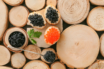 Bread with assortment of delicious caviar on wooden background
