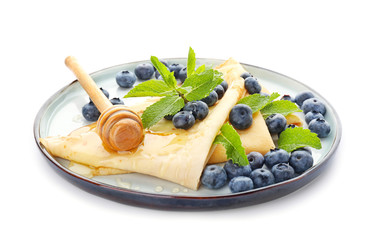 Plate with tasty blini, blueberry and honey on white background
