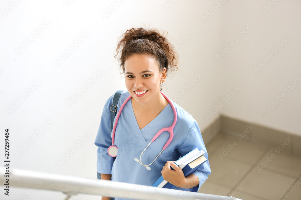 Sticker young african-american student on stairs in clinic