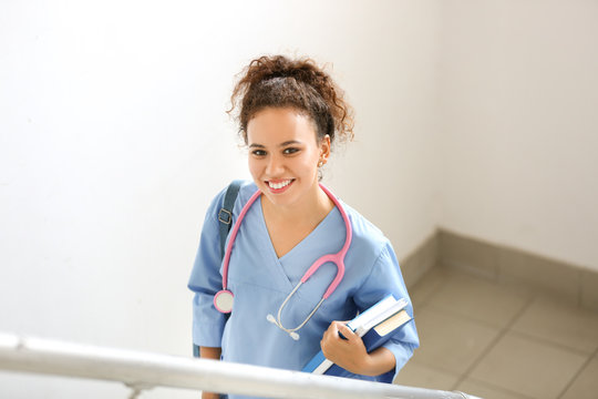 Young African-American student on stairs in clinic