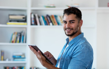 Modern mexican hipster man working with tablet computer