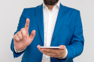 Businessman in the blue suite with lap top pointing with finger.
