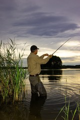 Angler catching the fish in the lake