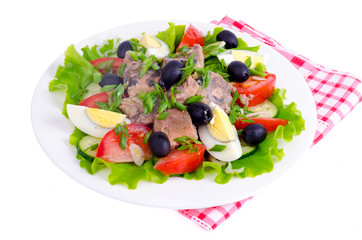 Salad of fresh vegetables, egg, canned fish and olives. 