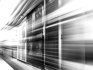 Datacenter server racks with network computers in neon black and white. Room with several of mainframe in big modern data center.