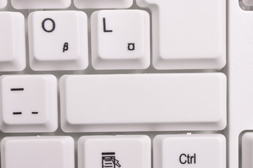 White pc keyboard with empty note paper above white background key copy space