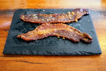 Two Slices of Country Bacon on a Slate Plate