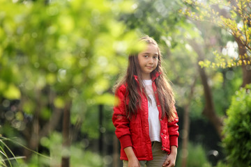 close up outdoor portrait of elementary age girl in sunny green garden