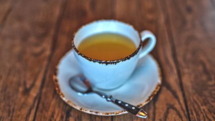 Cup of hot green tea in white ceramic Cup on wooden table