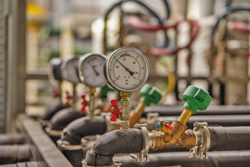 Gauge closeup, pressure measurement . Pipes and valves in the industrial enterprise.