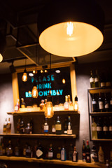 Vintage luxury interior lighting decor at Restaurant, cafe or bar. old Vintage light bulb lamps. Restaurant Bar or Cafe interior design. Vintage Light bulbs  in front of alcoholic drinks bottles shelf