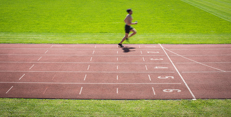 Runner on a running track finishing a race first (motion blurred image)