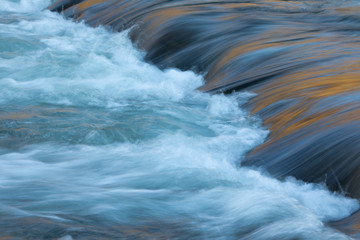 Water concept - river water flowing with light reflecting of its surface - long exposure shot