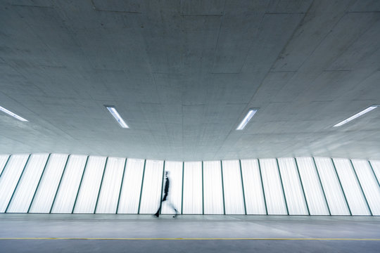 Motion blurred people - figures in an underpassage getting to their workplace in the morning. Busy city business life.